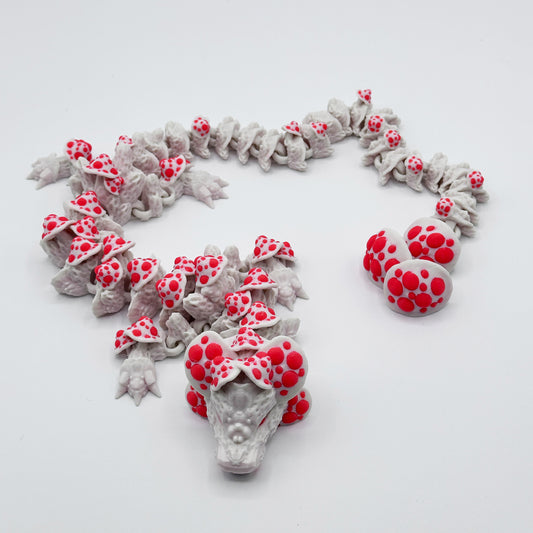 A detailed Highly Obtainable Cinder Wing Mushroom Dragon necklace with a central dragon head, crafted from sustainable PLA with red polka dots, is displayed on a light background. The beads resemble multiple smaller dragon heads in a repeating pattern, paired with matching circular earrings.